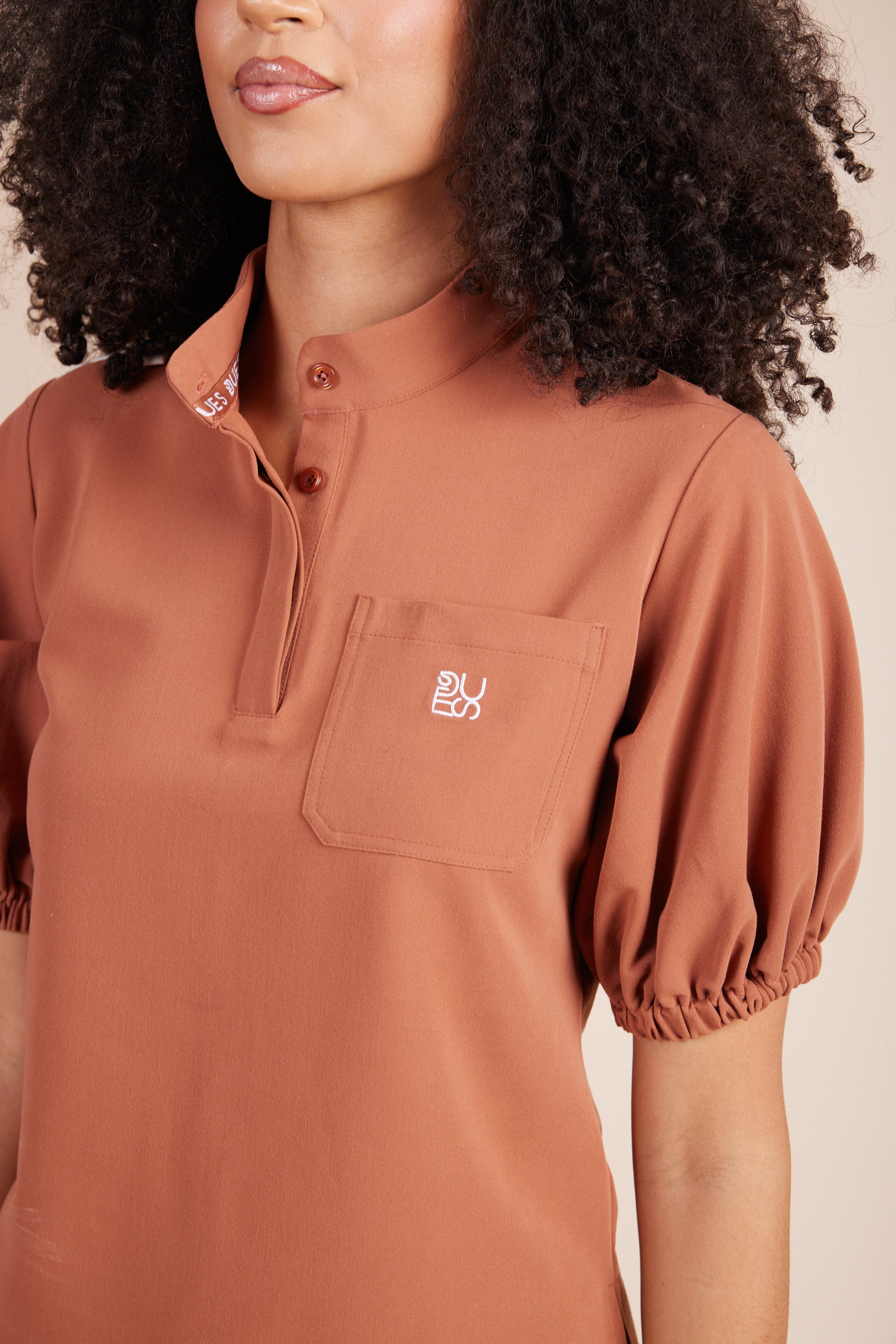 Helen Scrub Top in Terracotta by DUES – luxury scrub top sewn in the USA, featuring contrast key loops, side splits, and high-stretch panels for comfort and mobility.