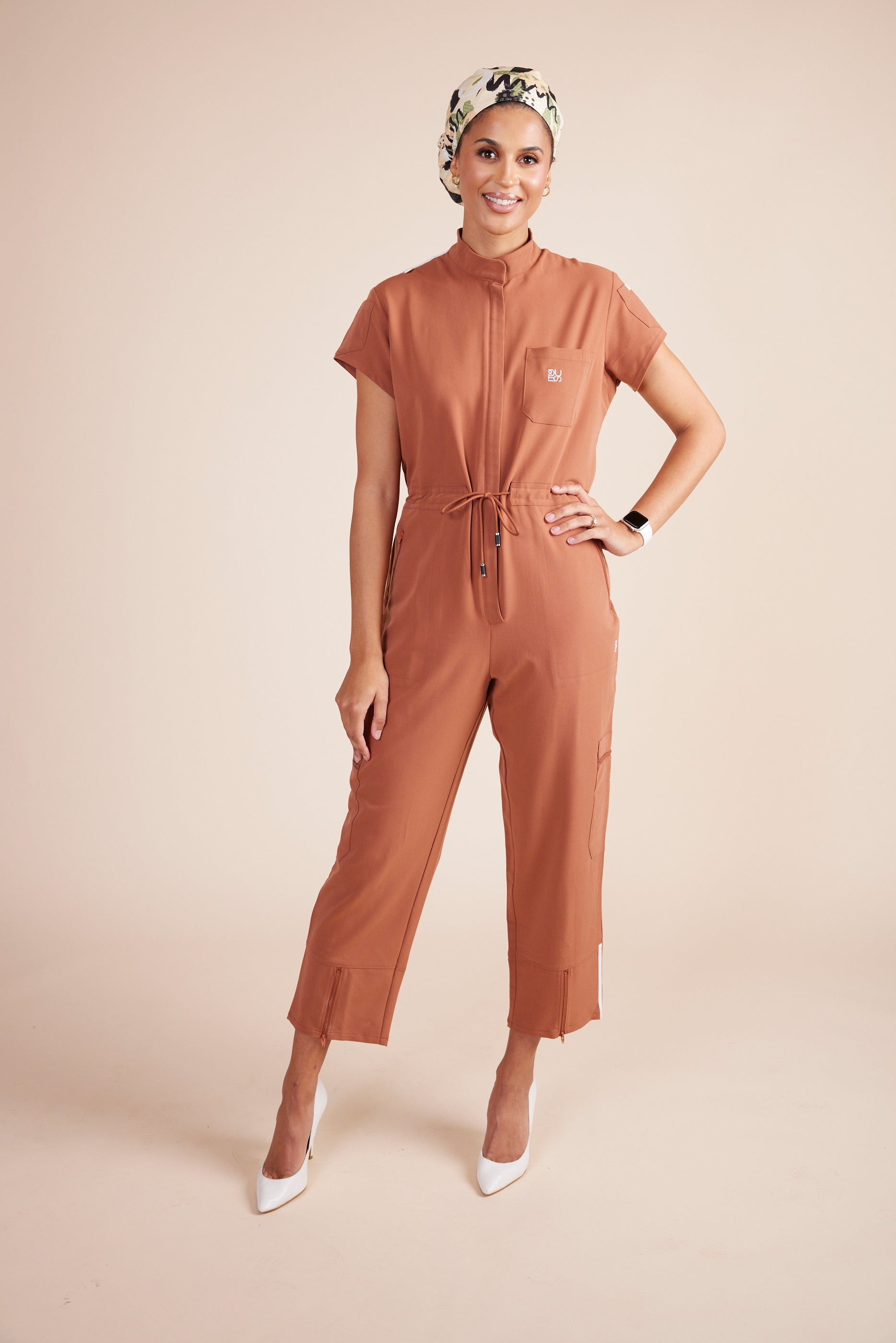 Ebony Scrub Jumpsuit in Terracotta by DUES – luxury scrub jumpsuit sewn in the USA, combining modern style with practical features like multiple pockets and stretch panels for unrestricted movement.