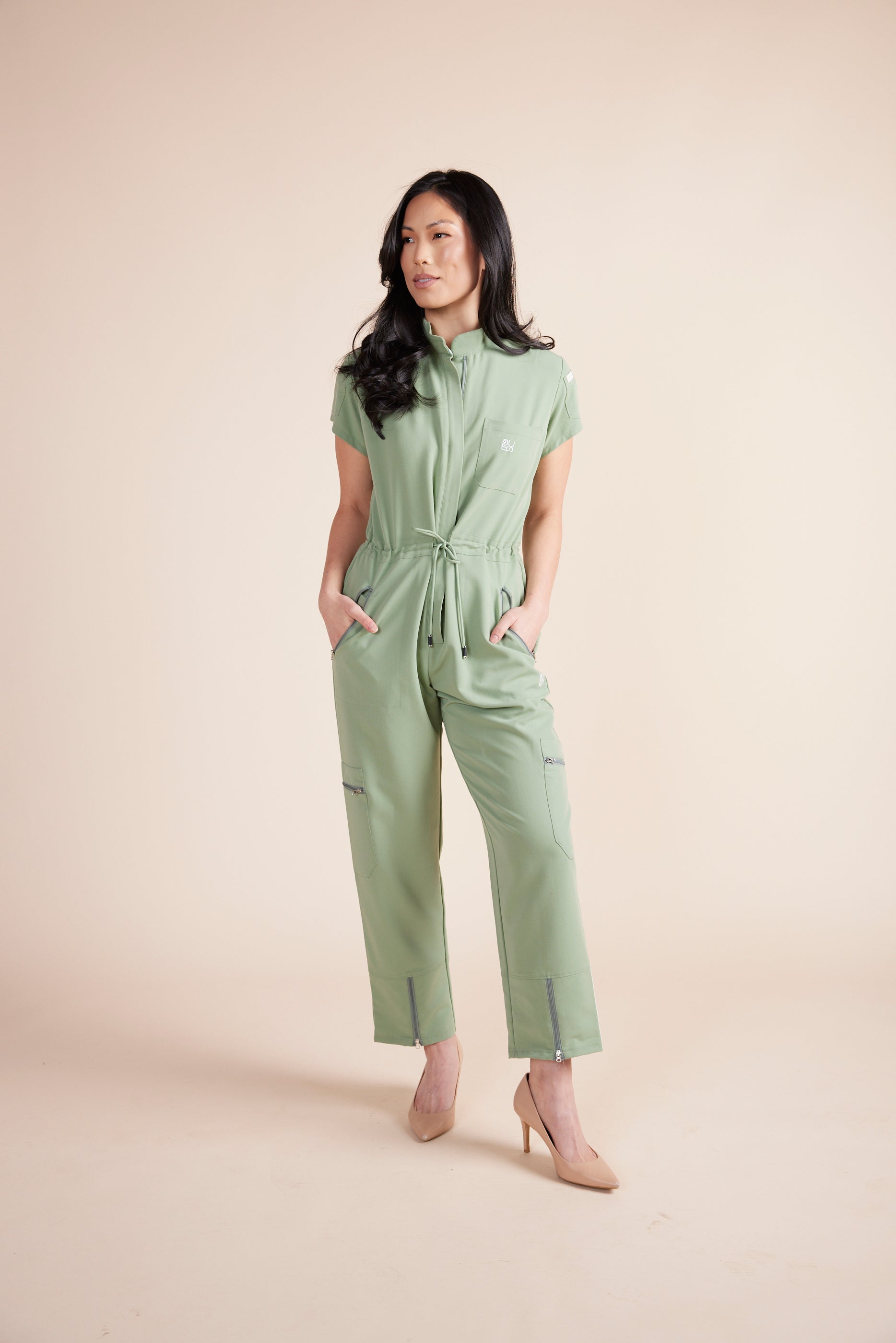 Ebony Scrub Jumpsuit in Green Tea by DUES – luxury scrub jumpsuit sewn in the USA, offering a polished one-piece design with breathable, high-performance fabric for ultimate comfort.