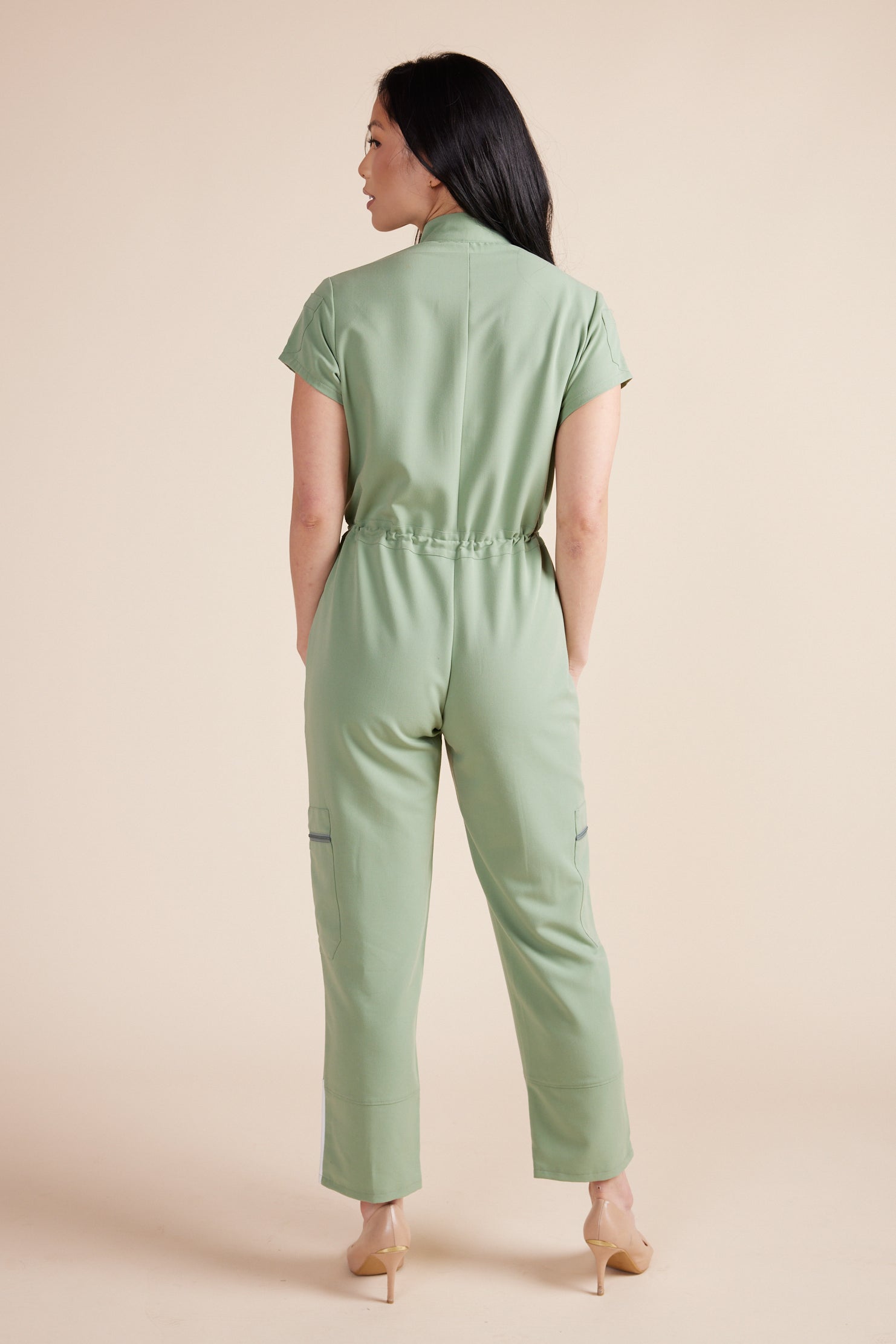 Ebony Scrub Jumpsuit in Green Tea by DUES – luxury scrub jumpsuit sewn in the USA, offering a polished one-piece design with breathable, high-performance fabric for ultimate comfort.